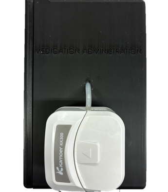 The peristaltic pump head mounted on the front of the medication administration enclosure.